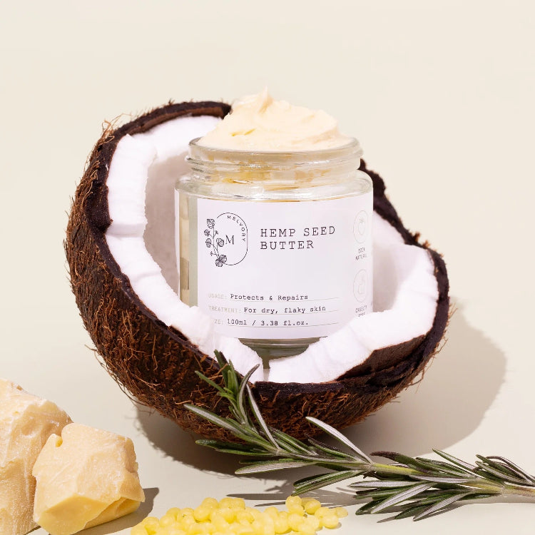 Jar of hemp seed butter inside a coconut shell with a light background
