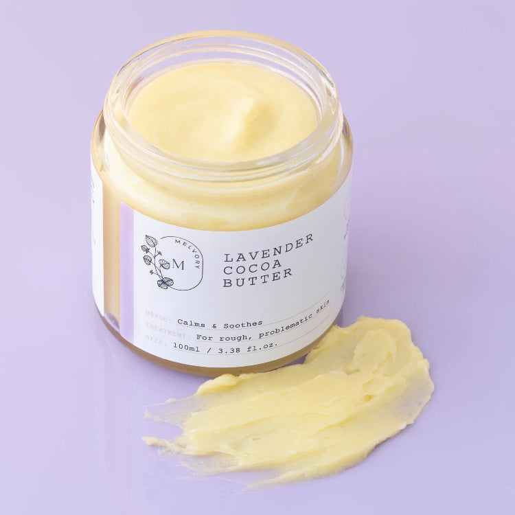 Jar of lavender cocoa butter cream with a smear of cream on a purple background